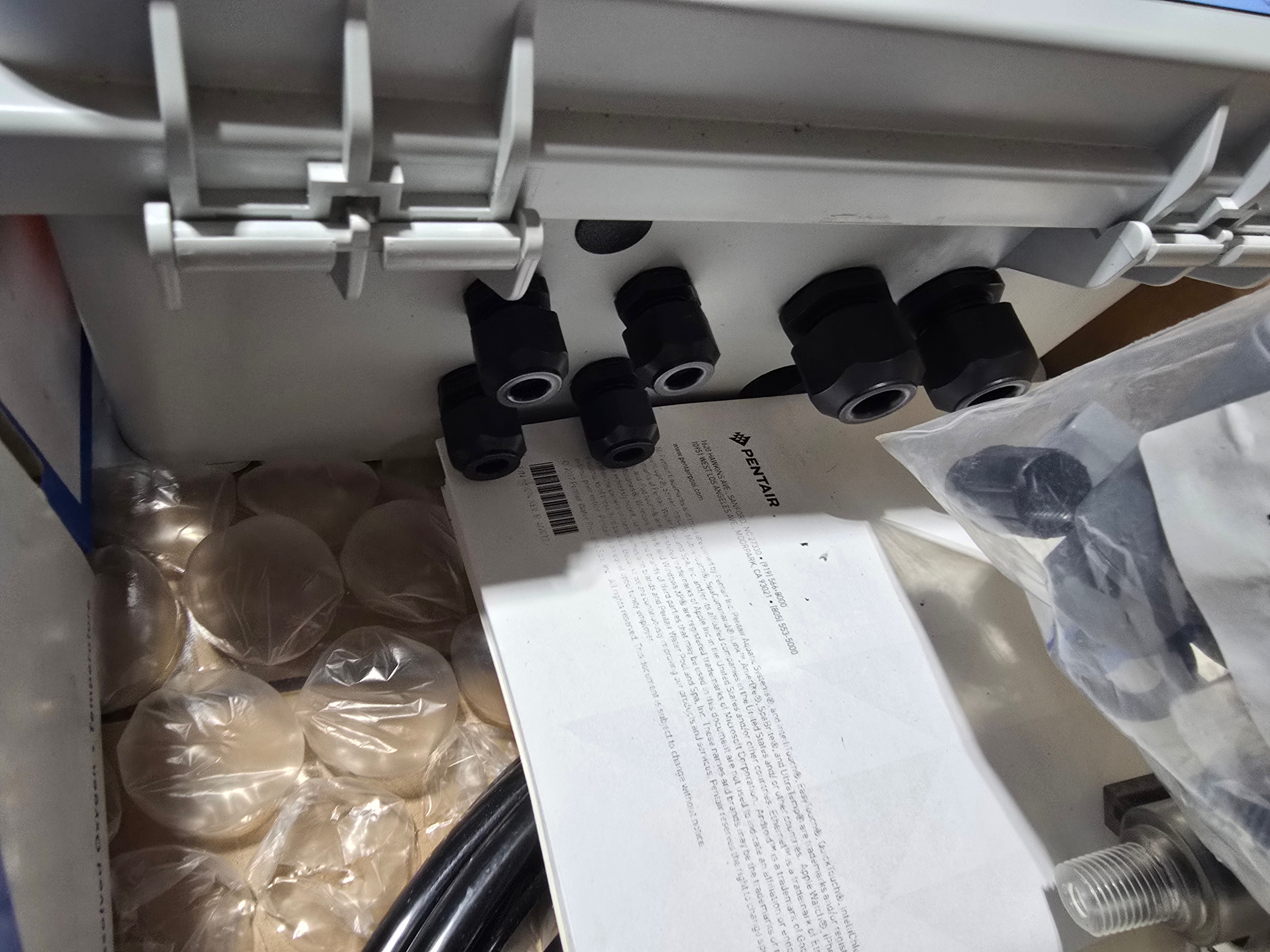 Pentair IntelliChem hardware bag — fittings, silicone lubricant, probe brush, and plumbing connectors